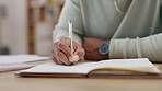 Man, hands and writing in book on table for schedule, planning or daily diary for tasks at home. Hand of male with notebook and pen to write project plan, task or reminder in financial budget on desk