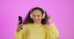 Dancing, headphones and phone of woman isolated on purple background for music on mobile app or social media audio. Gen z black person using phone and listening to radio or dance to sound in studio