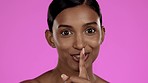 Happy woman, face and finger on lips for secret to skincare, cosmetics and body wellness on pink background. Portrait, smile and female model for silence on mouth, beauty and quiet with shush hands
