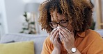 Allergy, sneezing and sick woman blowing nose, wiping and control of sinusitis. Covid, fatigue and a girl with a sinus problem, virus and cold, flu or hay fever on the living room sofa with a tissue