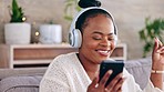 Dance, headphones and black woman on couch, smartphone and streaming music in living room. Dancing, African American female and lady with cellphone, headset and sounds for movement and stress relief