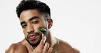 Face, beauty and man with facial roller, skincare and cosmetics against a grey studio background. Portrait, male ad guy with rose quartz, treatment and grooming with confidence, smooth and soft skin