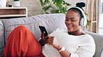 Dance, smartphone and black woman with headphones, audio streaming and stress relief on couch. Music, African American female and lady with headset, cellphone and dancing in lounge, sounds and smile