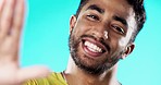 Selfie, laughing and face of a man with a smile isolated on a blue background in a studio. Happy, cheerful and portrait of a young guy taking a photo, smiling and posing for a picture on a backdrop