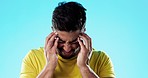 Stress, headache and man athlete in a studio with a cold, flu or covid symptoms rubbing his head. Sickness, frustration and tired male with a migraine, burnout or medical emergency by blue background