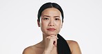 Beauty, unsure and face of an Asian woman in a studio with a skincare, self care and natural routine. Thinking, doubtful and portrait of a female model with dermatology treatment by white background.