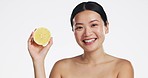 Lemon, face and beauty of woman in studio, white background and vegan wellness. Happy asian model, portrait and citrus fruits for facial cosmetics, vitamin c skincare and natural detox dermatology 