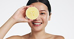 Lemon, face and woman in studio, natural wellness and white background. Happy asian model, beauty portrait and citrus fruits for facial cosmetics glow, vitamin c skincare or detox dermatology results