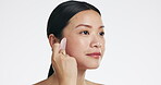 Gua sha, beauty and woman massaging face isolated on a white background in a studio. Spa, skincare and an Asian girl with a product to massage for facial relaxation, treatment and anti aging