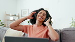 Music headphones, laptop and woman dance on sofa in home living room. Technology, computer and happy female streaming, listening or enjoying audio, podcast or radio on couch in lounge while dancing.