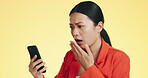 Asian woman, phone and shocked for bad news, loss or disbelief against a studio background. Female face in shock with facial expression on smartphone for terrible text, message or alert on mockup