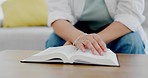 Hands, bible book and table with woman, reading and religion for peace, learning and personal growth. Closeup, paper and worship god with relax mindset on living room sofa in home with education