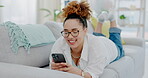 Woman, phone and lying on sofa chatting for communication or social media in living room at home. Happy female texting on mobile smartphone app relaxing on lounge couch for chat, search or browsing