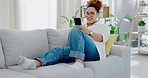 Woman, phone and texting on sofa to relax with social media, meme and communication internet in house. Gen z girl, smartphone and chat with app ux, tech or watch video with smile in home living room