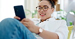 Happy woman relax on sofa and phone for internet, social media post or texting on mobile app at home. Young biracial person on couch or lounge scroll and typing on a cellphone, smartphone or web chat