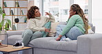 Friends, women and talking on sofa, bonding in home living room and communication. Girls, friendship relax and smile of happy females chatting, speaking or discussion, sharing story or conversation.