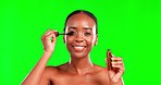 Makeup, face and black woman with mascara in a studio for a beauty, natural and cosmetic routine. Happy, smile and portrait of African female model with eyelash cosmetics by a green screen background