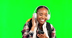 Green screen, dancing and black woman listening to music or streaming online, internet or on mobile app and having fun. Student, headphones and female using phone for radio or audio in studio