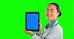 Green screen, tablet and doctor face isolated on studio background for telehealth, medical or service software app. Healthcare professional or Asian person with digital technology and mock up space