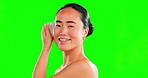 Face smile, skincare and Asian woman with stone on green screen in studio isolated on a background. Dermatology, cosmetics portrait and happy female model with rose quartz gua sha for skin massage.