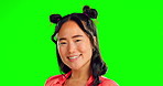 Portrait, winking and an asian woman on a green screen background in studio feeling playful or flirty. Face, smile or silly with a happy and attractive young female posing on chromakey mockup