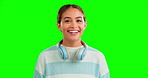 Happy, funny and a woman on a green screen background in studio with headphones around her neck. Portrait, smile and humor with an attractive young female listening to music on chromakey mockup