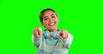 Happy woman, point and face of gen z on green screen studio with headphones for choice, you and mock up background. Smile, portrait and hand gesture, emoji and girl showing sign on isolated space