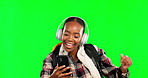 Dancing, cool and student listening to music or black woman dance isolated in studio green screen background. Trendy, headphones and female streaming radio, audio or song on a phone or mobile app