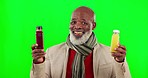 Choice, face and black man with juice on a green screen isolated on a studio background. Happy, health and portrait of an elderly African person holding drinks for a decision and choosing a bottle