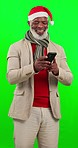 Green screen, Christmas and black man with smartphone, typing and connection against a studio background. Mature male, happy guy and senior citizen with cellphone, chatting and post to social media