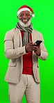 Christmas, green screen and black man with smartphone, face and joyful against a studio background. Portrait, African American male and guy with Xmas hat, cellphone and connection for social media