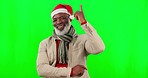 Pointing up, senior face and black man with green screen and christmas hat showing deal. Isolated, studio background and elderly person in winter holiday point for product placement and announcement