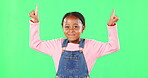 Children, pointing and a black girl on a green screen background in studio for marketing a product. Kids, portrait and advertising with a cute little female child showing space on chromakey mockup