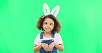 Kids, easter and playful with a girl on a green screen background in studio feeling silly while having fun. Children, bunny and holiday with a cute little female child playing on chromakey mockup