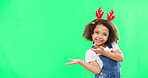 Christmas, green screen and a girl presenting advertising space for product placement in studio. Portrait, kids or celebration with an adorable little child on chromakey mockup for the festive season