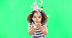 Little girl, birthday and blowing confetti on green screen for party celebration isolated against a studio background. Portrait of cute kid celebrating event with glitter decor for new year on mockup