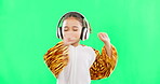 Children, music and a girl dancing on a green screen background in studio streaming audio while having fun. Kids, energy and freedom with a little female child dancing while listening to the radio