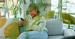 Happy woman, phone and laughing on a sofa at funny meme, post or joke in a living room. Smartphone, relax and girl reading online comic while relaxing on day off with social media, app or website