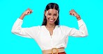 Business woman, arm flex and happy face of a Indian female feeling power, succes and win. Work victory, champion and confident young employee in a studio with isolated blue background and a smile