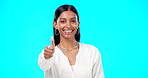 Thumbs up, perfect and portrait of woman with hand gesture for success, approval and isolated in studio blue background. Emoji, face and Indian female with fashion, perfection and support review