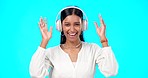 Face, dance and Indian woman with headphones, celebration and girl against a blue studio background. Portrait, female and lady with headset, streaming music and listen to sounds with joy and dancing