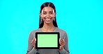 Space, green screen and face of a woman with a tablet isolated on a blue background in a studio. Mockup, smile and portrait of an Indian girl holding technology with a blank screen for advertising