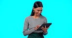 Employee, success and Indian woman with tablet, typing and connection against a blue studio background. Business owner, female entrepreneur and happy lady with device, communication or online reading
