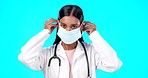 Studio woman, face mask and covid doctor, female surgeon or nurse for disease support, healthcare or pandemic help. Hospital policy compliance, safety portrait or medical person on blue background
