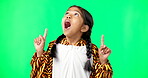 Green screen, shocked and child pointing up at mockup, product placement and isolated in a studio background. Excited, happy and portrait of a surprised kid in a costume showing discount or deal