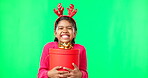 Christmas, gift box and happy with girl in green screen studio for youth, celebration and festive. Present, cheerful and vacation with portrait of child on background for season, holiday or happiness