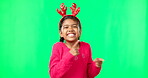 Child portrait, christmas and pointing on green screen with finger guns. Smile on face of a girl kid on a studio background with antlers headband for holiday celebration and mockup space with hands