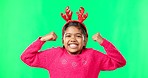 Child portrait, christmas and antlers on green screen flexing strong muscles or arms for motivation. Smile on face of a girl kid on a studio background with reindeer headband for holiday celebration