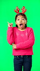 Christmas, antlers and idea with a girl on a green screen background in studio looking surprised. Children, portrait and eureka with an adorable little female child having an aha moment on chromakey