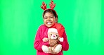 Happy, Christmas and face of a child with a teddy on a green screen isolated on a studio background. Bear, smile and portrait of a girl kid hugging a toy while excited for the festive season